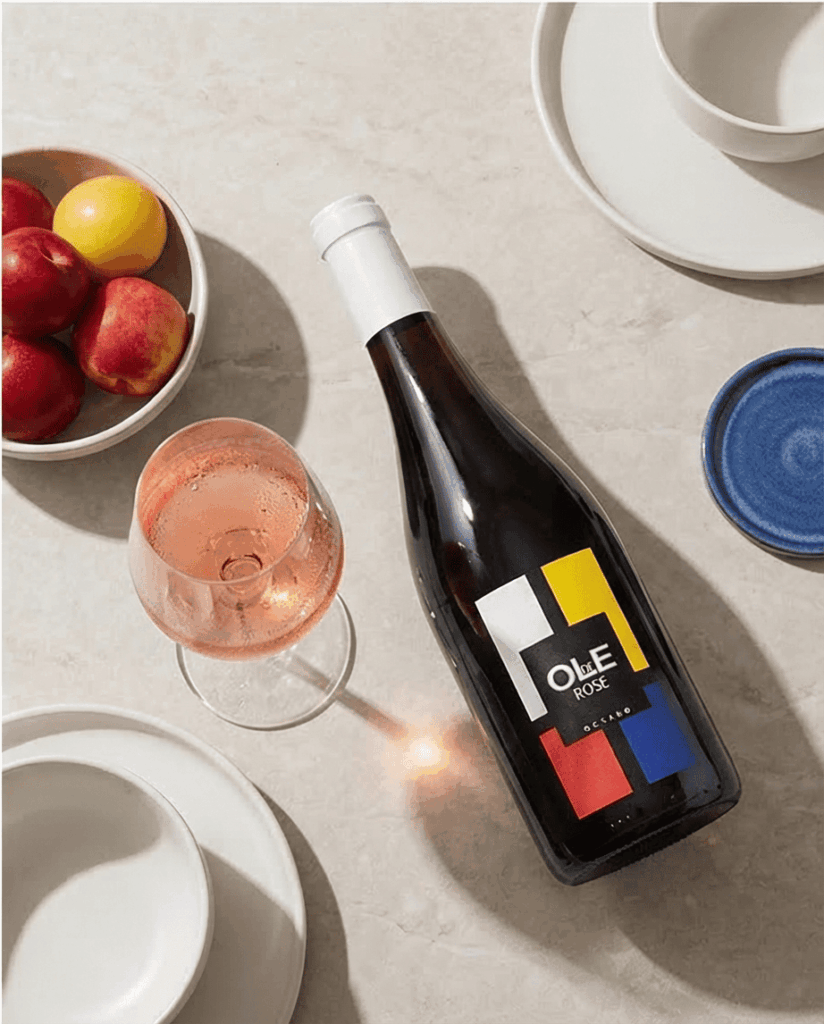 Fles ole de rosé ligt op tafel naast glas rosé.