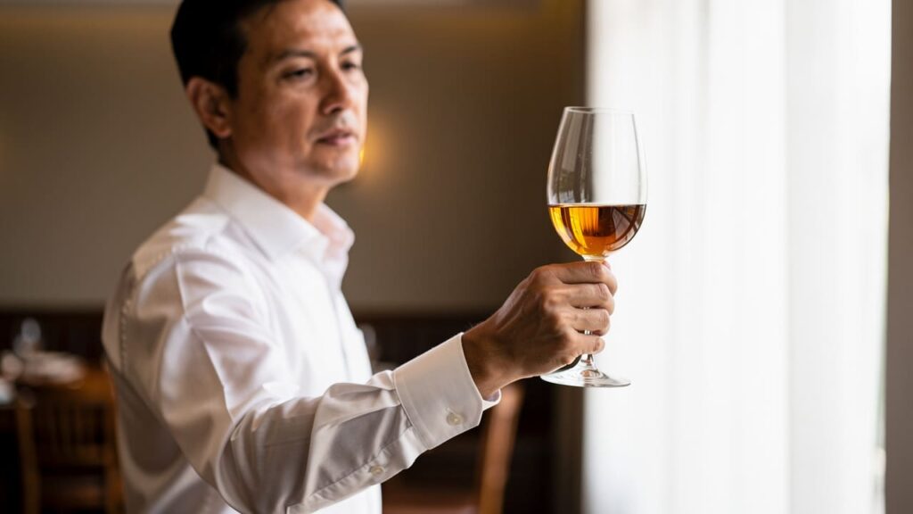Sommelier beoordeelt verkleurd glas wijn op kwaliteit.